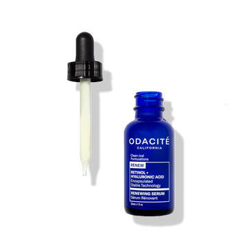 Odacité Renewing Serum Retinol + Hyaluronic Acid in a blue bottle with a dropper holding pale yellow liquid on a white background.