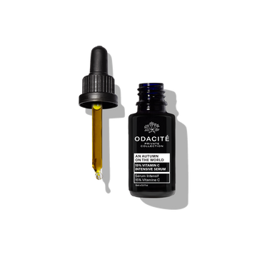 Dark Odacité bottle with dropper dispensing An Autumn On The World 15% Vitamin C Serum, on a white background.