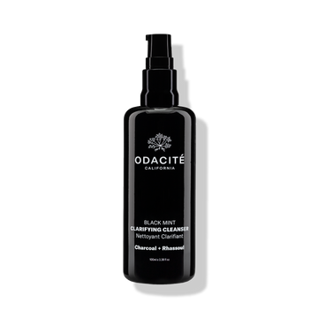 Black bottle of Odacite Black Mint • Charcoal + Rhassoul Clarifying Cleanser with pump dispenser on a white background.