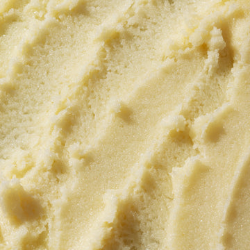 Smooth & Glow • Vitamin C Body Essentials by Odacité shown close up, pale yellow cream with a smooth, polished texture.