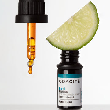 Odacite Firming Bu+L Buriti + Lime Serum Concentrate bottle with dropper and a lime on a plain white background.