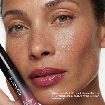 Woman with radiant skin and pink lips holds Odacité Glow More + Age Less Duo; “daily SPF” appears at the bottom.