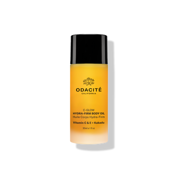 Odacité C-Glow • Hydra-Firm Body Oil in a yellow bottle with Vitamins C & E plus Kakadu, shown as a liquid skincare product.