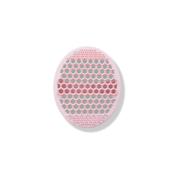 The Odacité Pore & Face Cleansing Brush is a round pink silicone mat with textured bristles.