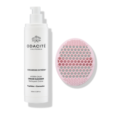 Odacité Daily Calm Cleansing Duo with a tube of cream cleanser and a pink silicone brush on a white background.