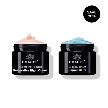 Odacité Deep Moisture Duo with two black jars: Restorative Night Cream (pink label) and Repair Balm (blue label).