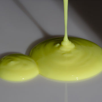 Derm-Restore Super Serum by Odacité with Edelweiss Extrême® shown as glossy yellow puddles on a surface.