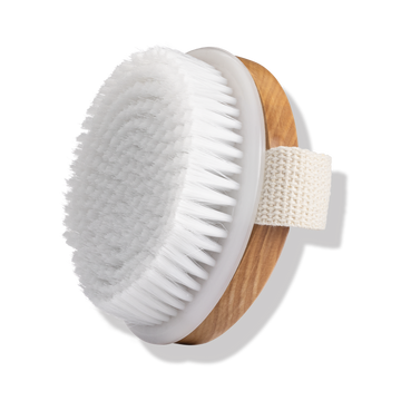 Odacité Odacite Dry Spa Brush with white round vegan bristles, light wooden base, and attached strap for hand grip.