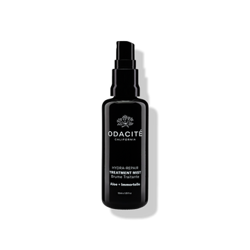 Black Odacite Hydra-Repair • Aloe + Immortelle Treatment Mist bottle with a spray nozzle and white label text.