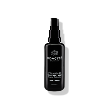 Odacite Hydra-Vitalize • Rose + Neroli Treatment Mist in a black spray bottle on a white background with visible shadow.