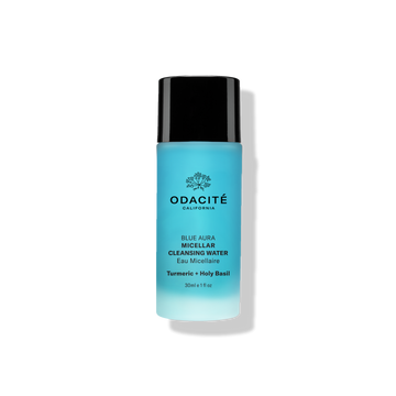 Odacité Blue Aura Turmeric + Holy Basil Micellar Cleansing Water in a blue bottle with a black cap on a light background.