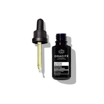 A dark blue Odacite Youthful Purity Serum • A Spring in Tokyo bottle on a plain white background.