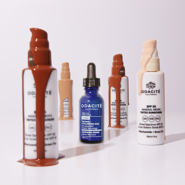Odacité Anti-aging Dream Duo SPF 50 and Retinol bottles on white background, with serum drops near the blue retinol bottle.