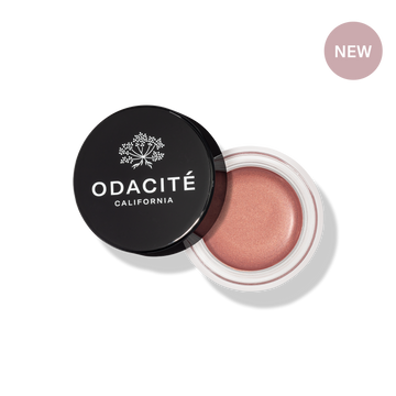 Odacité SPF 50 Color Balm Duo with black lid, open to show a shimmery pink shade. 