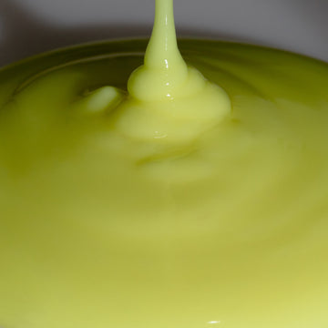 Creamy yellow liquid from Odacité Edelweiss Extrême Skin Barrier Set is poured, forming swirls on the surface.