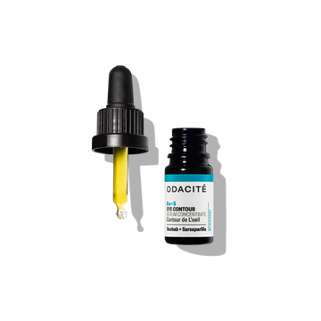 Dropper with yellow serum next to open Odacité Ba+S Eye Contour Serum Concentrate on a white background.