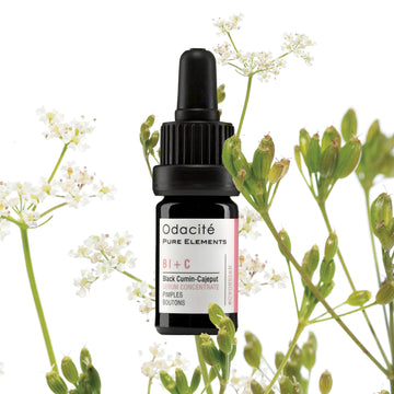 Odacite Clear + Decongest Pimple-Prone Duo dropper bottle placed among white flowers and green stems on a white surface.