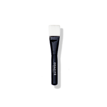 The Odacité Facial Brush with a black handle and soft vegan bristles, designed for applying face masks.