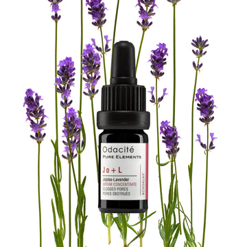 Odacite Clear + Decongest Pimple-Prone Duo bottle placed among lavender flowers on a white surface.