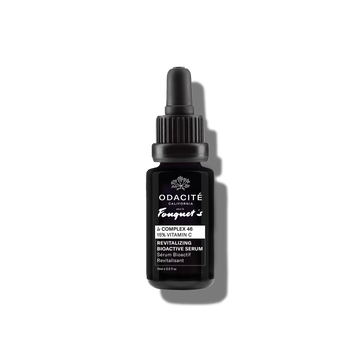 Black dropper bottle of Odacité Le Complex 46 Revitalizing Bioactive Serum, 15% Vitamin C, with white label on gray background.
