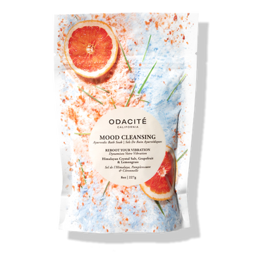 Odacite Relax & Recenter Bath Set with a clear bag, pink Himalayan salt, dried grapefruit slices, and green herbs on white background.