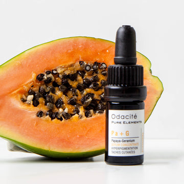 Halved papaya beside Odacite Brighten + Balance Uneven Skin Duo, both on a plain white background.
